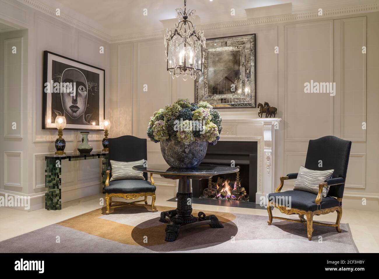 Flower arrangement under chandelier with armchairs Stock Photo Alamy