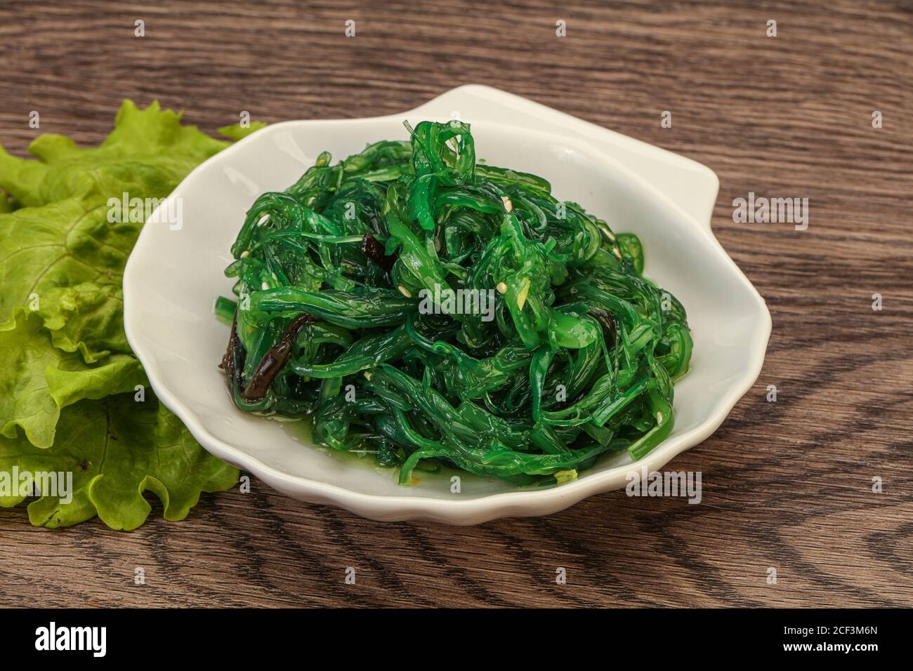 Green Chuka Seaweed Salad Isolated on White Background Top View. Wakame Sea Kelp Salat, Chukka Sea Weed, Healthy Algae Food Stock Photo