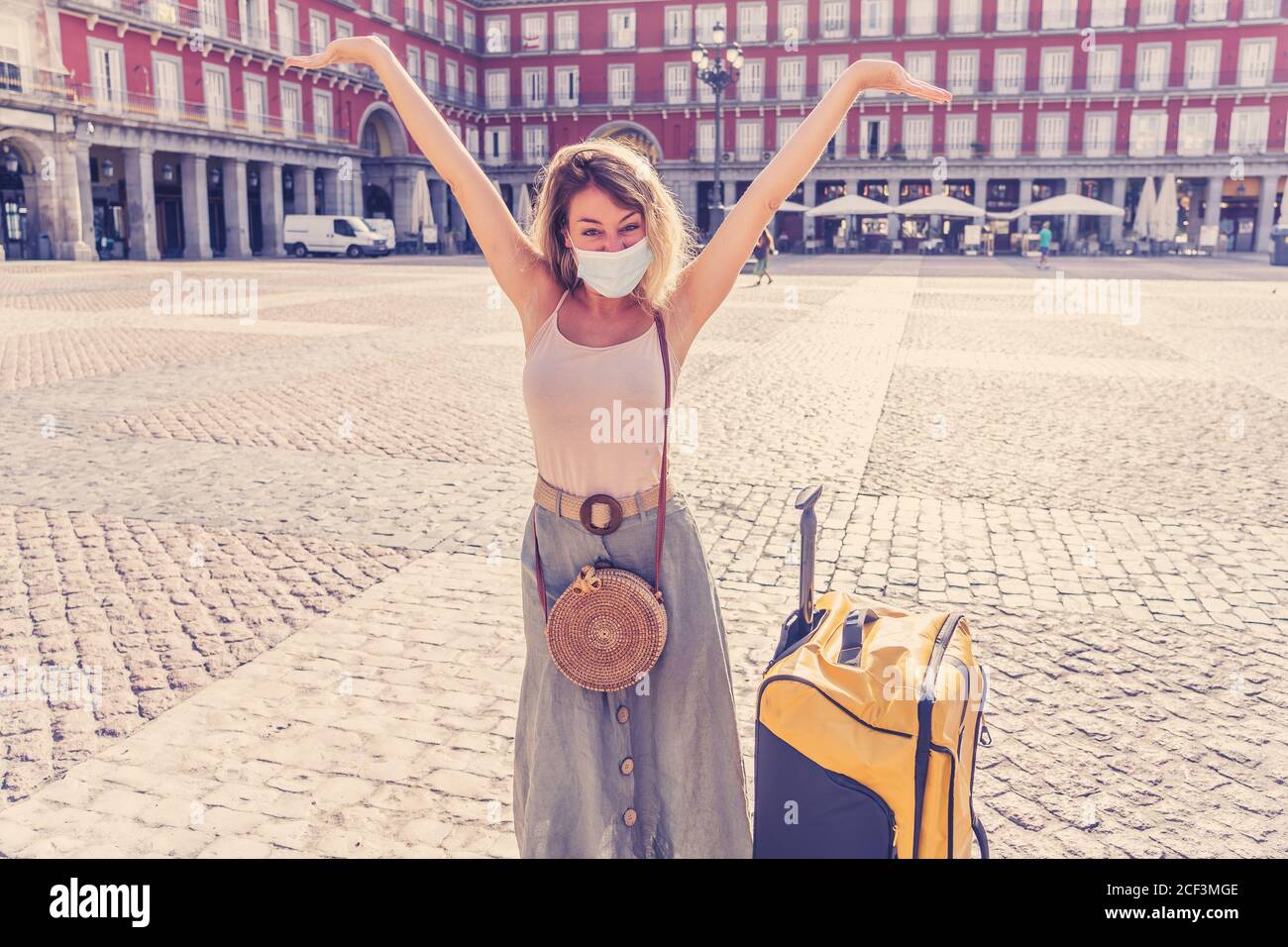 Young tourist woman wearing protective face mask happy and excited in Plaza Mayor Madrid Spain enjoying holidays in Europe after coronavirus outbreak Stock Photo