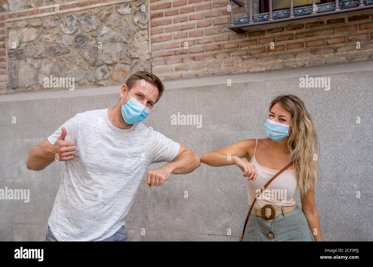 Safer way of greeting in the New Normal. Man and woman foot shaking and elbow bumping keeping social distancing to avoid Coronavirus spread. COVID-19 Stock Photo