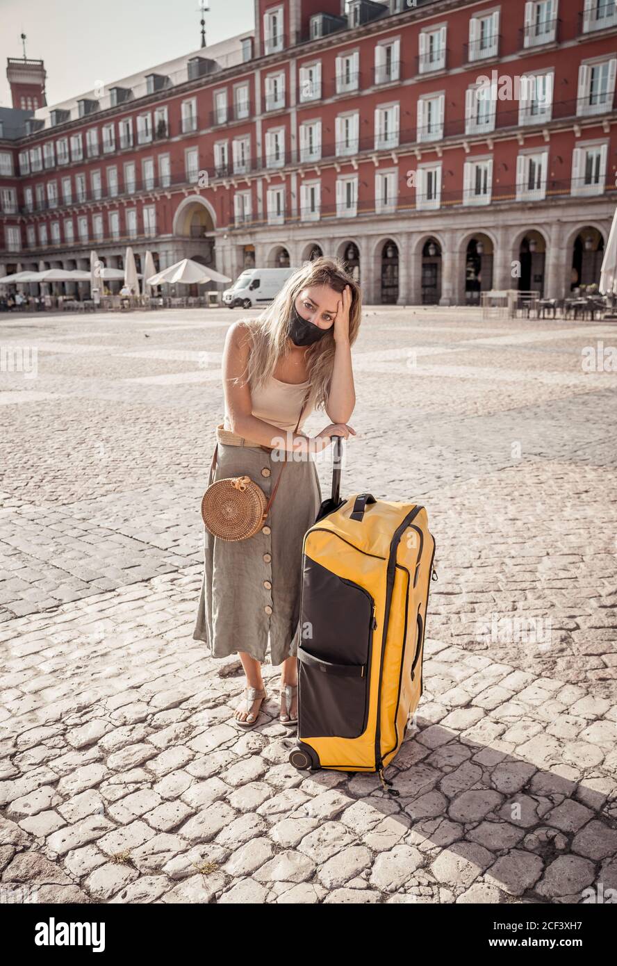 COVID-19 impact in tourism. Sad tourist wearing protective mask in Madrid Spain worried about coronavirus quarantine amid travel regulations. Vacation Stock Photo
