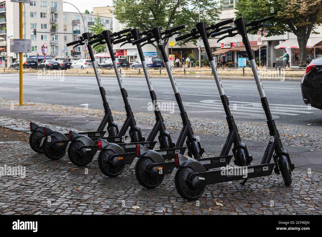 six e-scooters from the company Bird in a row on the sidewalk in Berlin Stock Photo