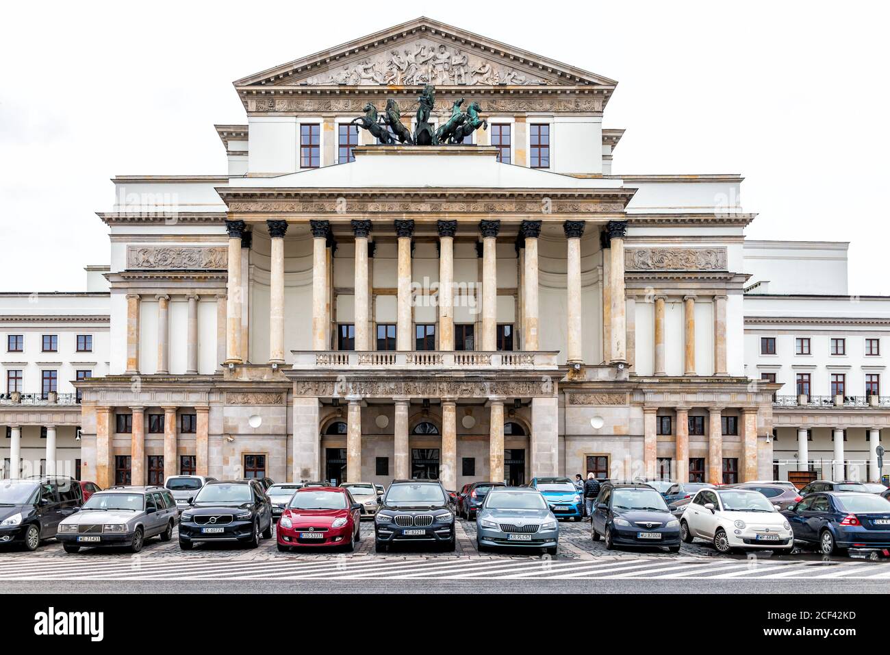 Warsaw, Poland - December 25, 2019: National opera n winter of Warszawa cloudy day exterior facade architecture view and stone columns with cars in pa Stock Photo