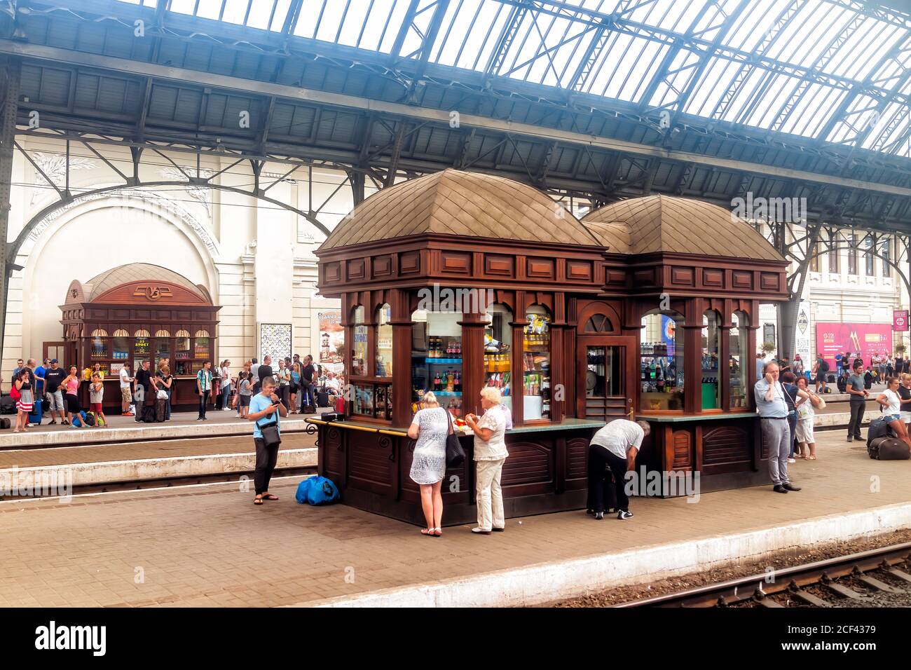 Lviv, Ukraine - July 30, 2018: Interior architecture of Lvov train station platform with kiosk store and people waiting with luggage in historic Ukrai Stock Photo