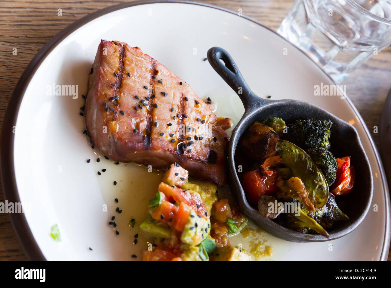 Grilled tuna steak garnished with avocado and tomatoes Stock Photo Alamy