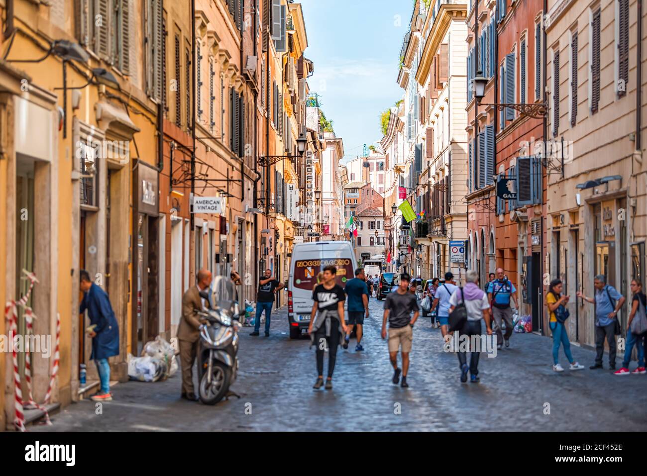 Rome, Italy - September 4, 2018: Narrow city town road Via Frattina street with signs for stores shops restaurants and people walking on sunny day Stock Photo
