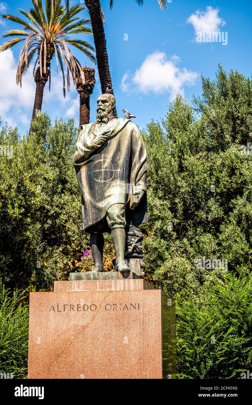 Rome, Italy - September 4, 2018: Historic green park on Via della Domus Aurea street with statue of Alfredo Oriani and sign and birds blue sky Stock Photo