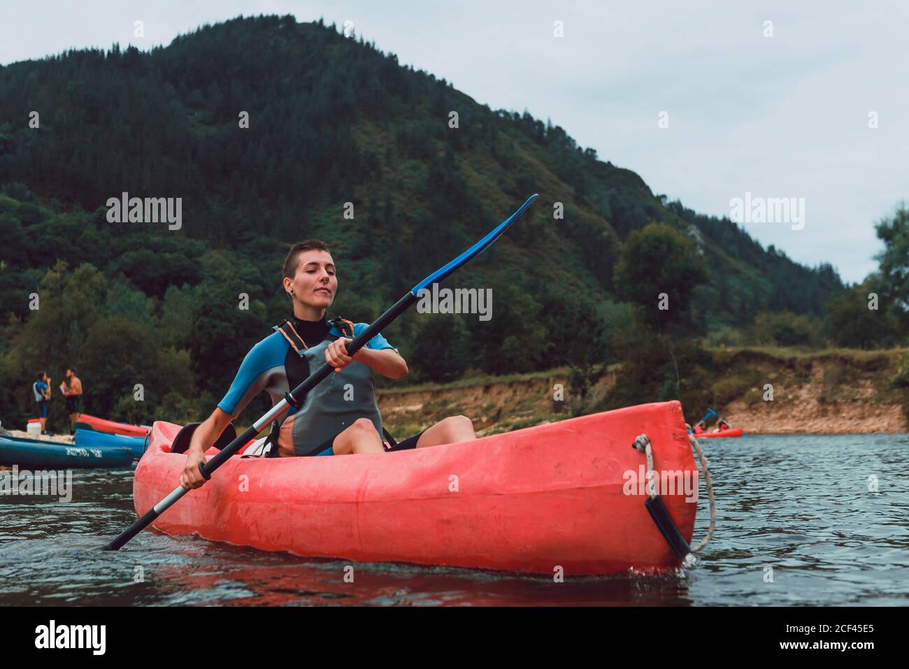Sportive Woman sitting in red canoe and paddling on Sella river decline in Spain Stock Photo