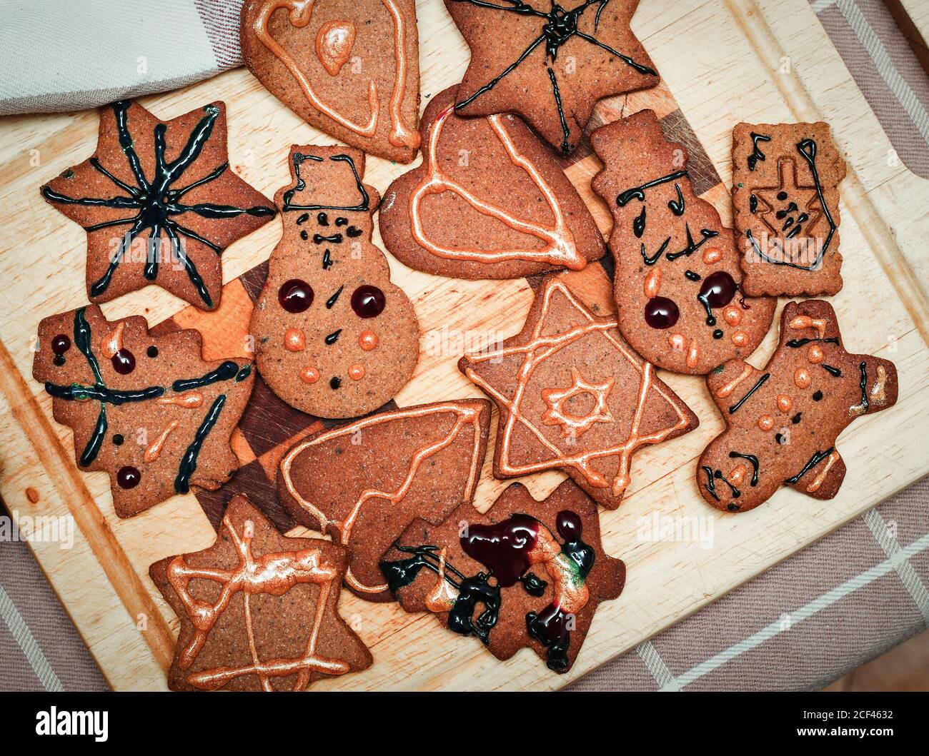 Children hand decorated christmas gingerbread cookie figurines on kitchen board Stock Photo