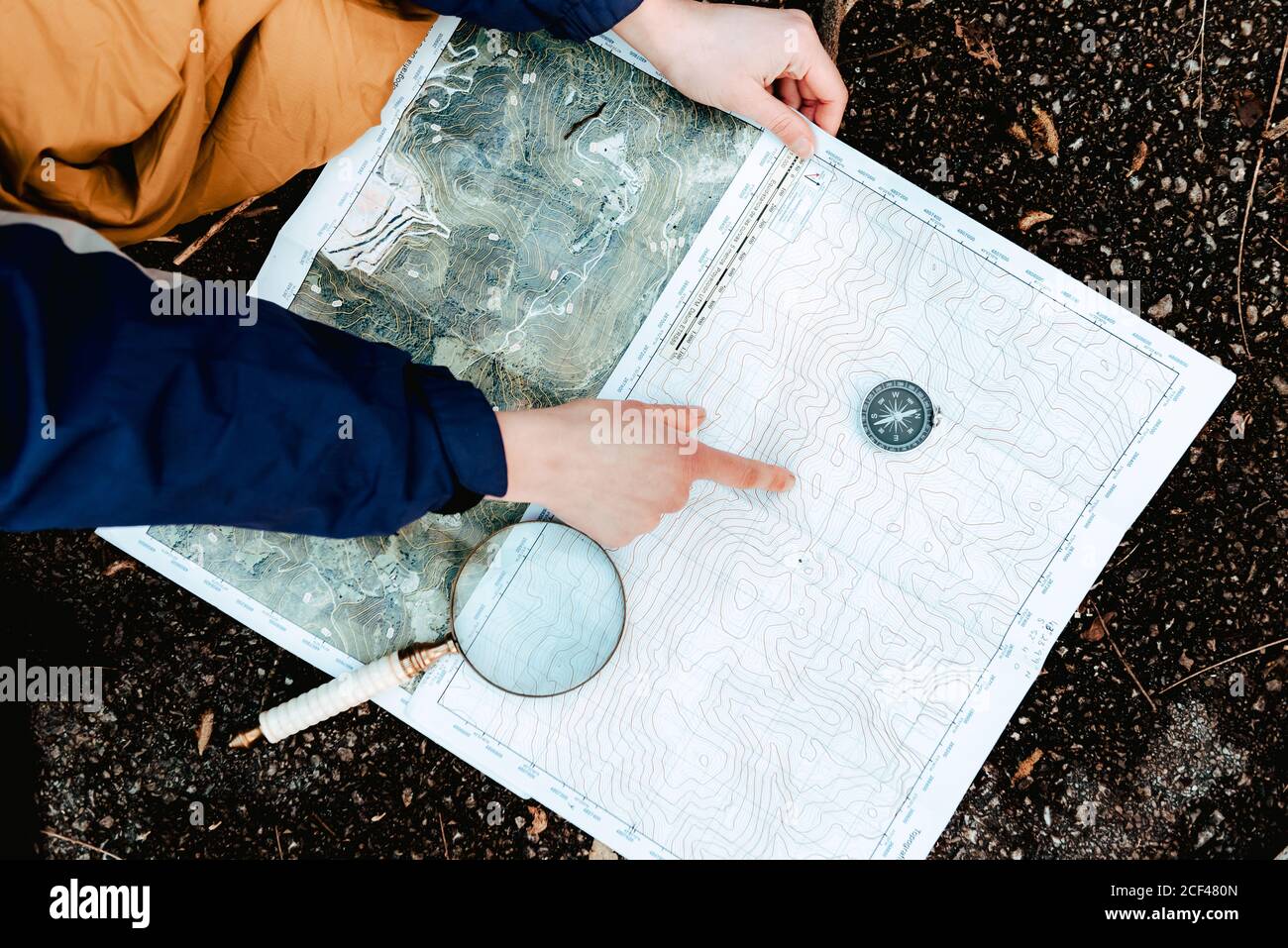 unrecognizable hiker navigating with map and compass in countryside Stock Photo