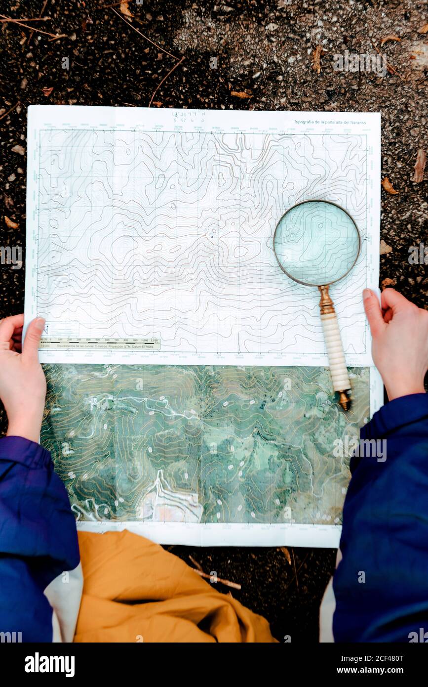 unrecognizable hiker navigating with map and compass in countryside Stock Photo
