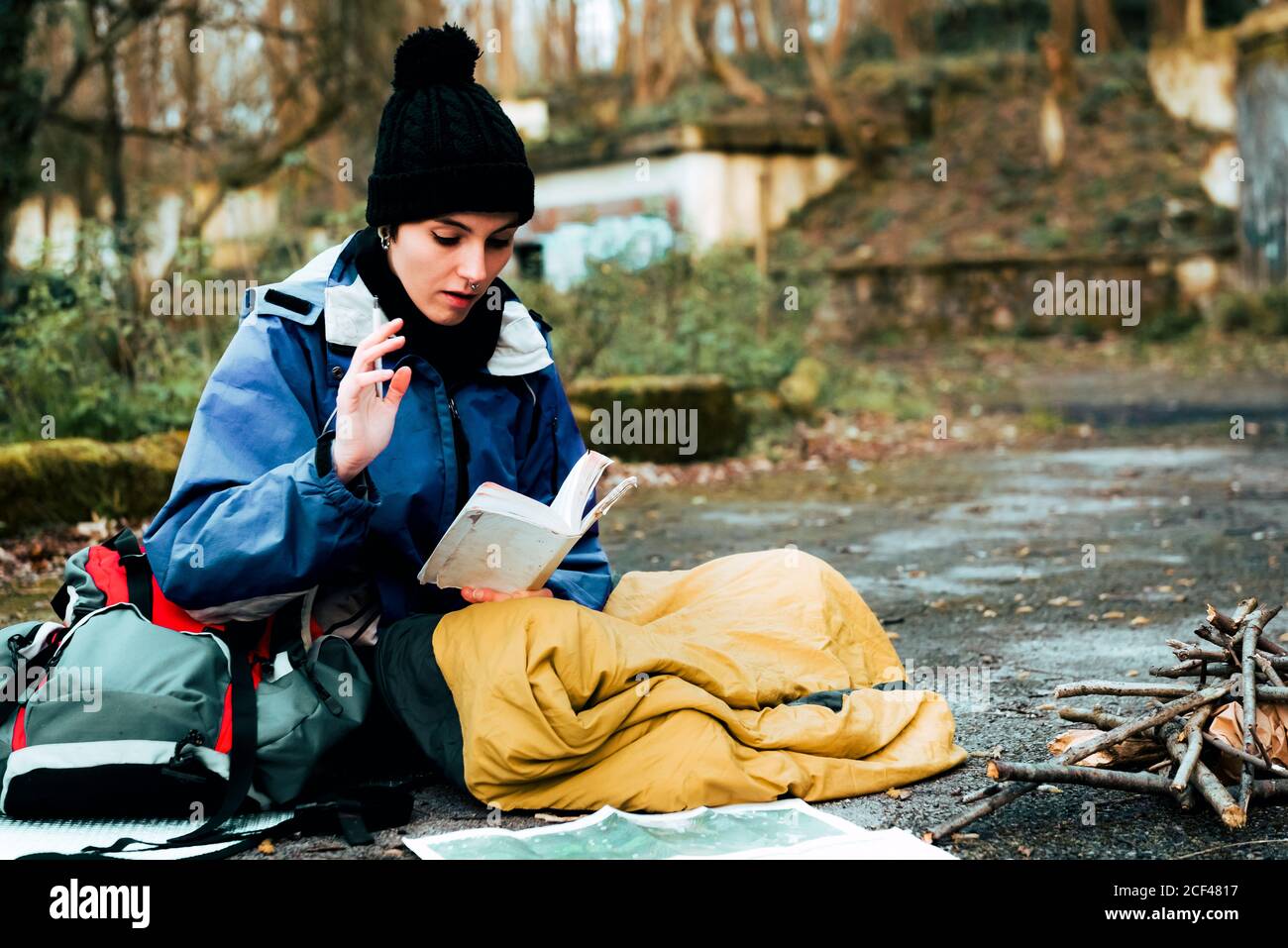 Young female backpacker making notes at campfire Stock Photo