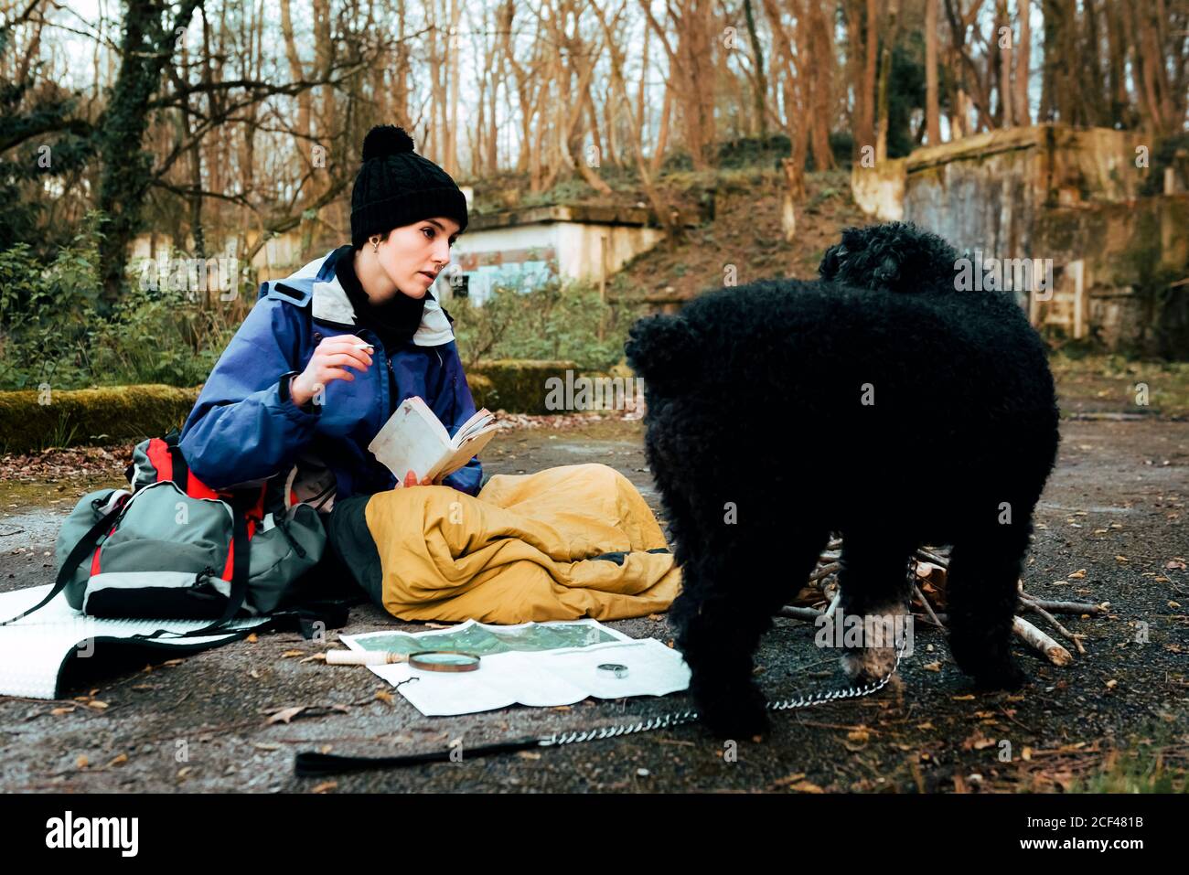 Young female backpacker making notes at campfire Stock Photo