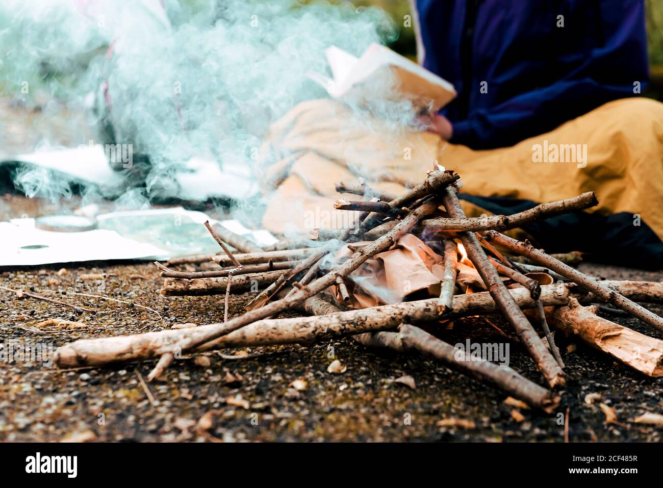 Young female backpacker making notes at campfire Stock Photo