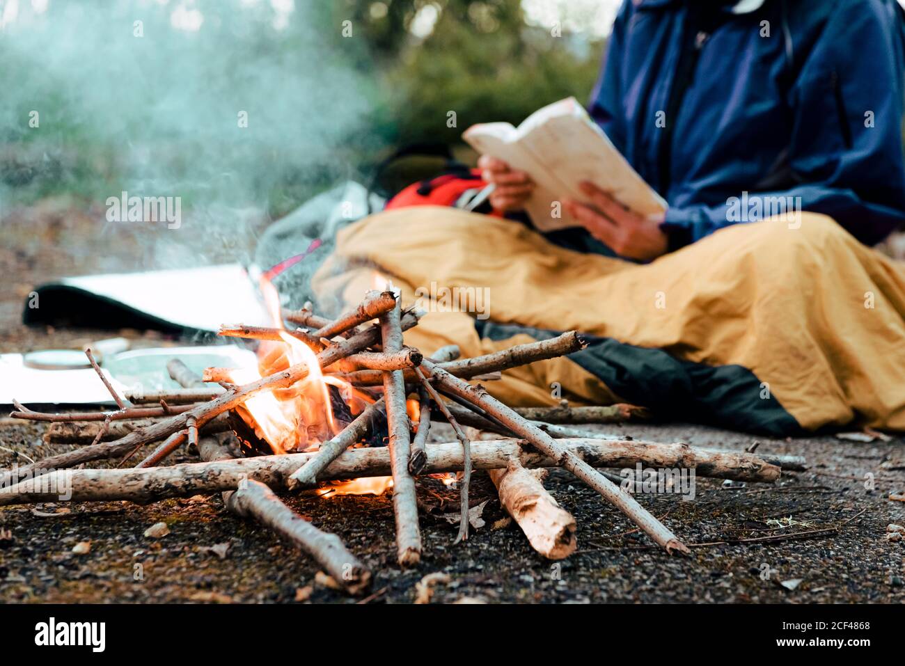 Young female backpacker making notes at campfire Stock Photo