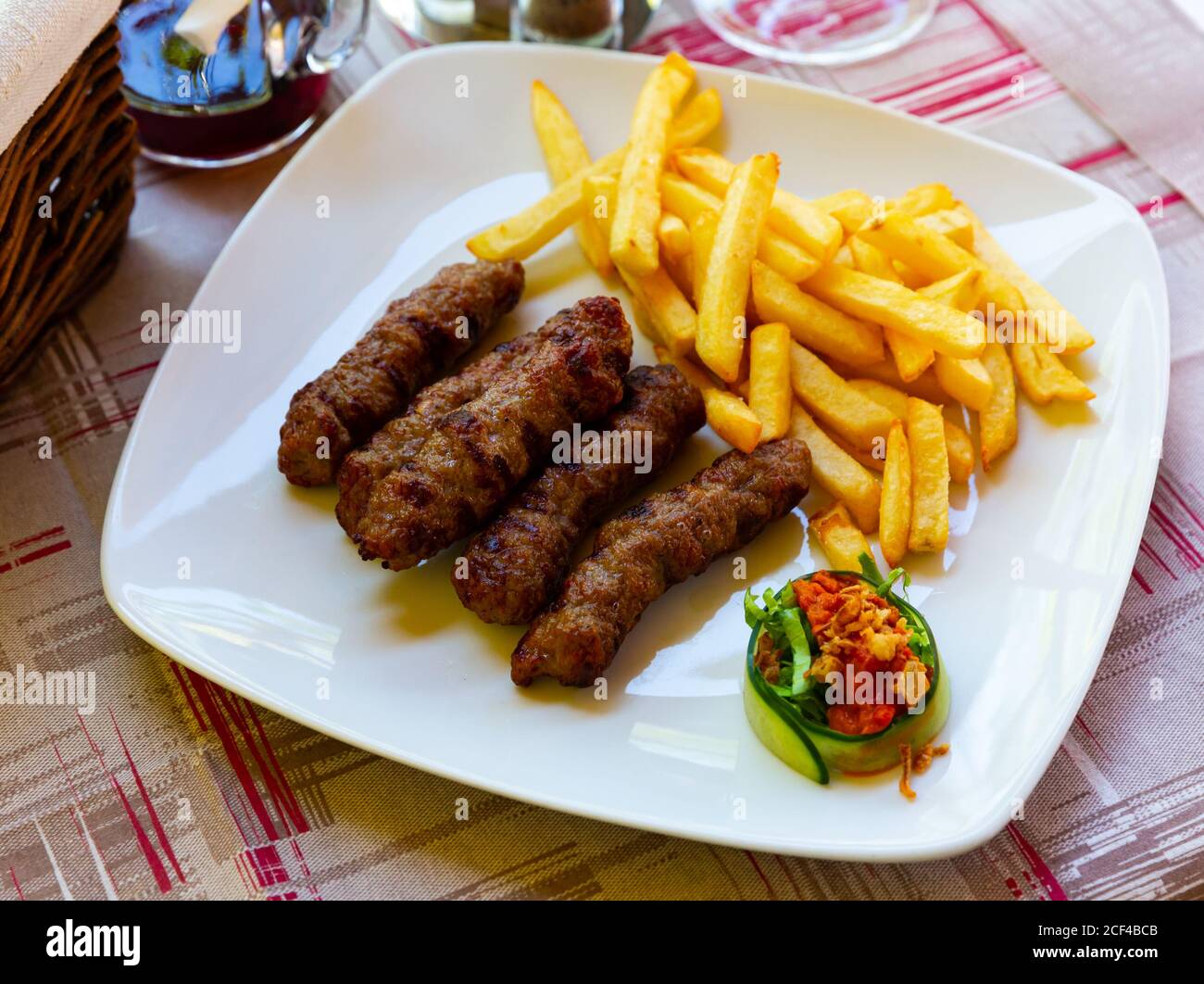 Cevapi - grilled dish of minced meat with french fries. Balkan cuisine Stock Photo