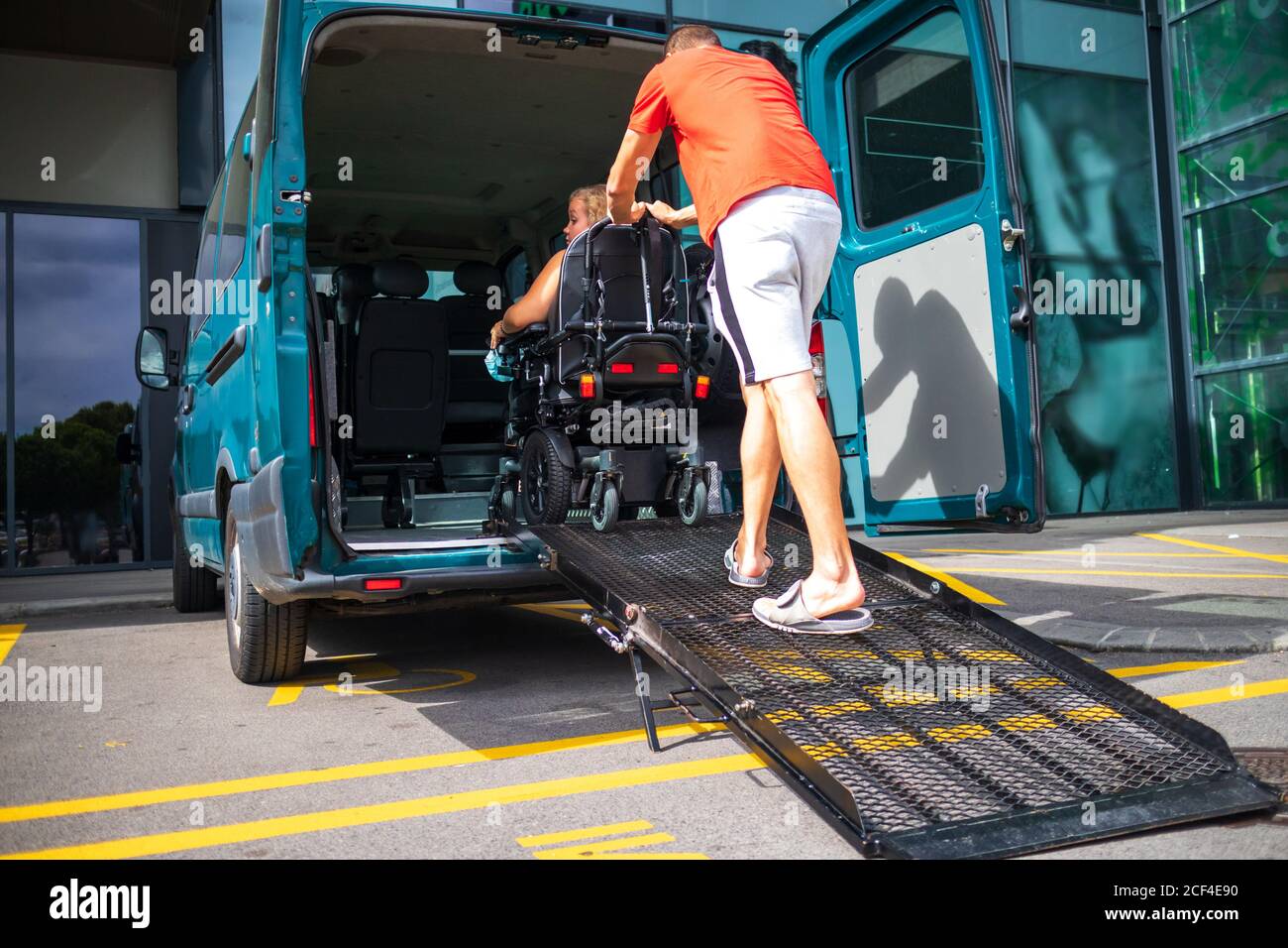 Woman on wheelchair using a vehicle ramp. Accessible transport with