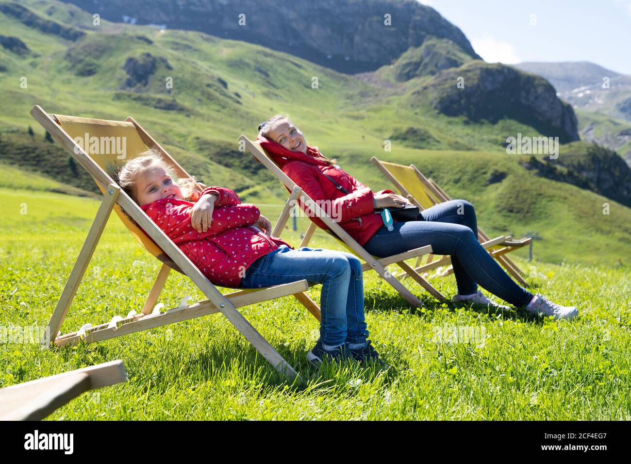 Mother And Child Relaxing Outdoor In Sunbeds In Mountains Stock Photo