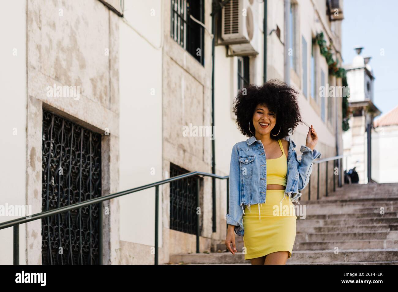 Beautiful African American Woman in yellow suit standing on stairs and ...