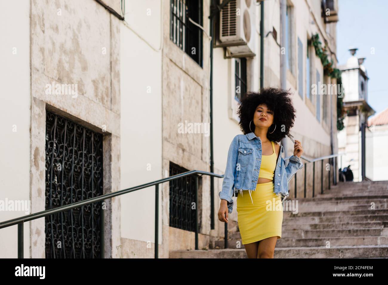 Beautiful African American Woman in yellow suit standing on stairs and ...