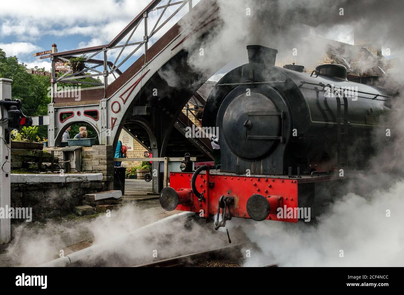 Steam Locomotive Repulse, engulfed in steam, pulls out of Haverthwaite station on a branch railway line heading for Lakeside in the Lake District (UK) Stock Photo