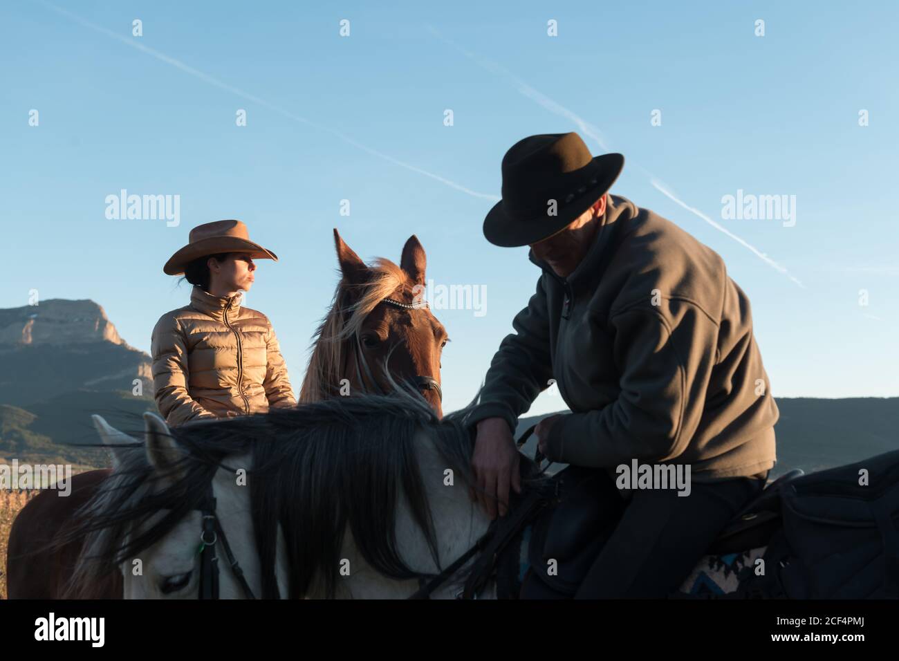 man and Woman riding horses against sunset sky on ranch Stock Photo - Alamy