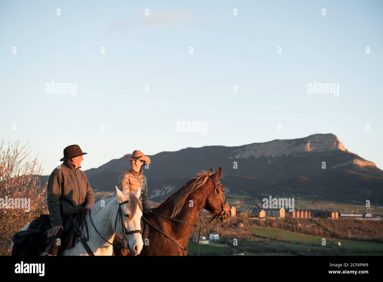 man and Woman riding horses against sunset sky on ranch Stock Photo - Alamy