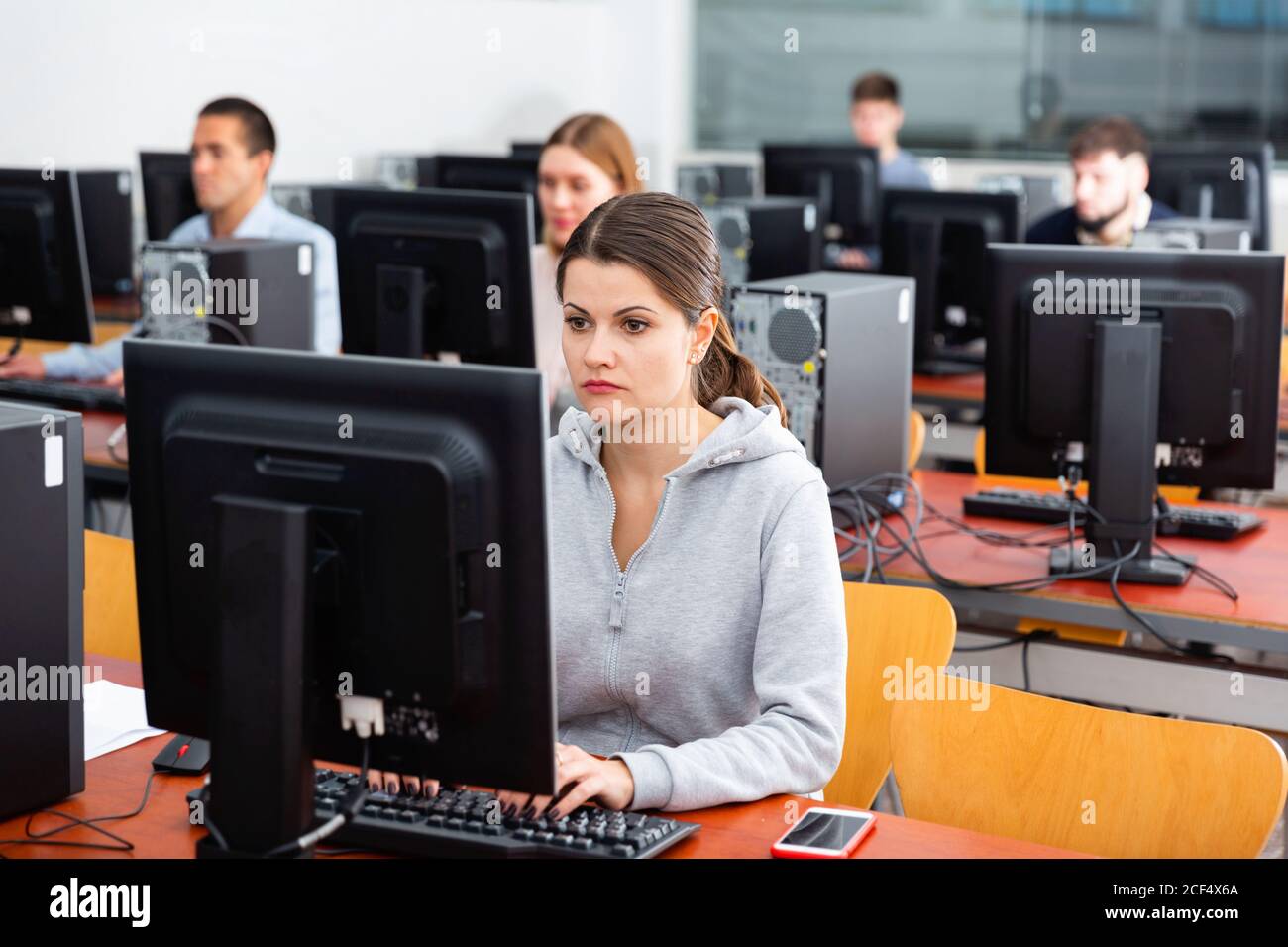 Diligent friendly smiling  teacher conducts computer science exam in university class Stock Photo
