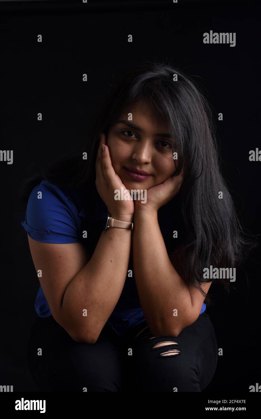 portrait of a latin woman sitting on chair and looking at camera on