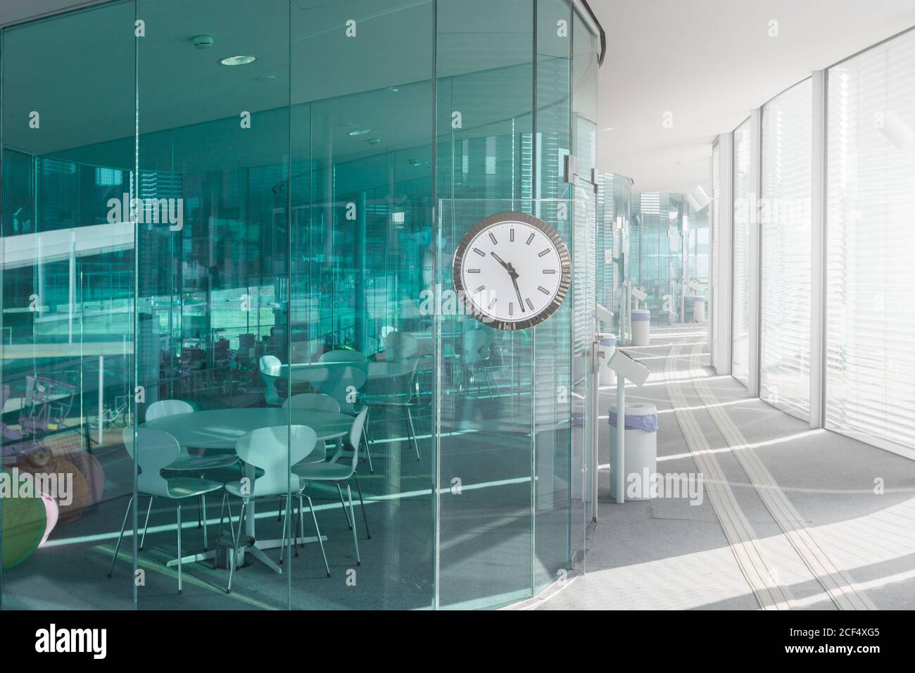 Design of modern office with blue transparent walls and light hallway with  clock, Switzerland Stock Photo - Alamy