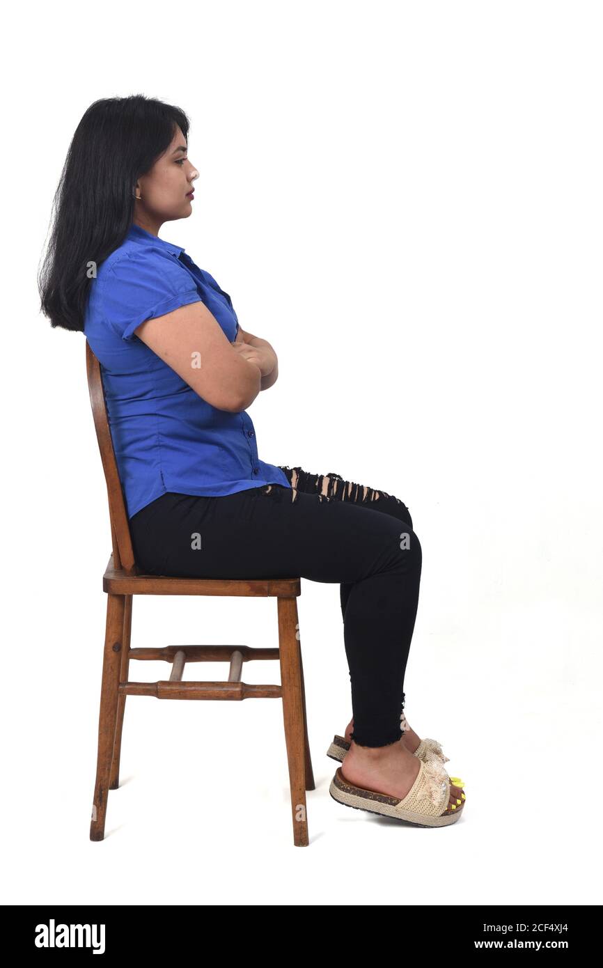 side view of portrait of a latin woman sitting on a chair in white