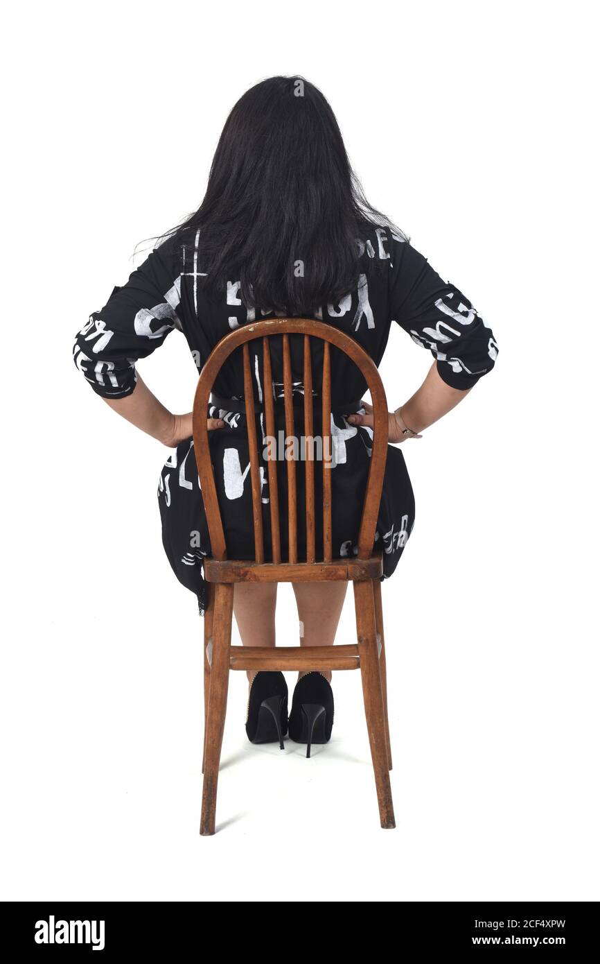 rear view latin woman with dress and high heels sitting on chair on