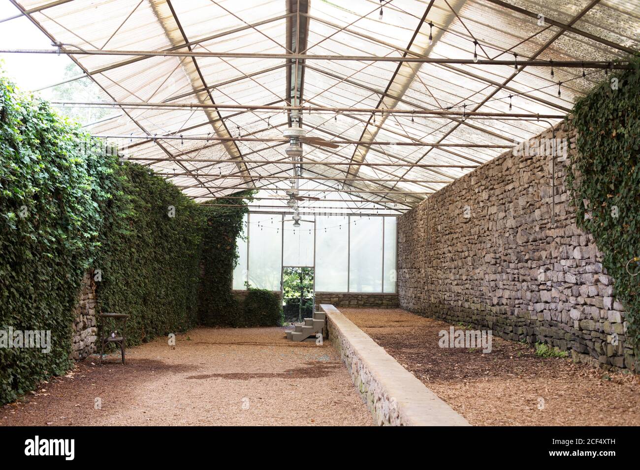 An empty greenhouse with rock wall at the Knoxville Botanical Garden in
