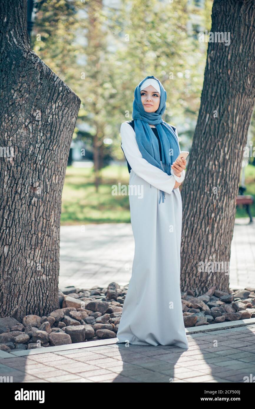Beautiful muslim girl in blue hijab looking in camera. Full length ...