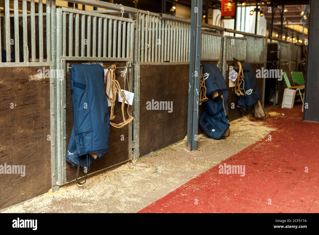 Barn sections with closed doors and hanging equipment for horse riding Stock Photo