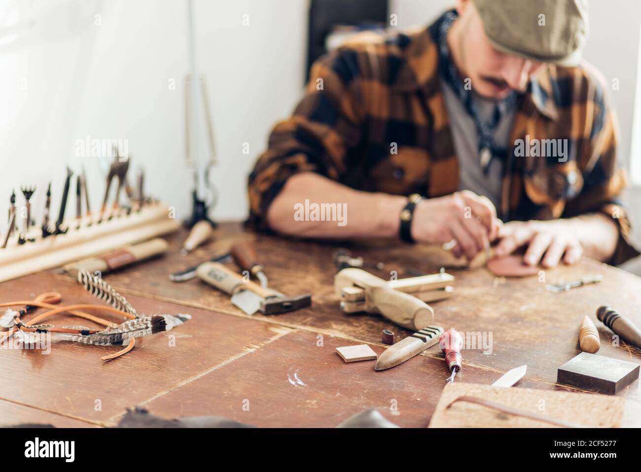 Man working with leather using crafting DIY tools. focus on tools Stock Photo