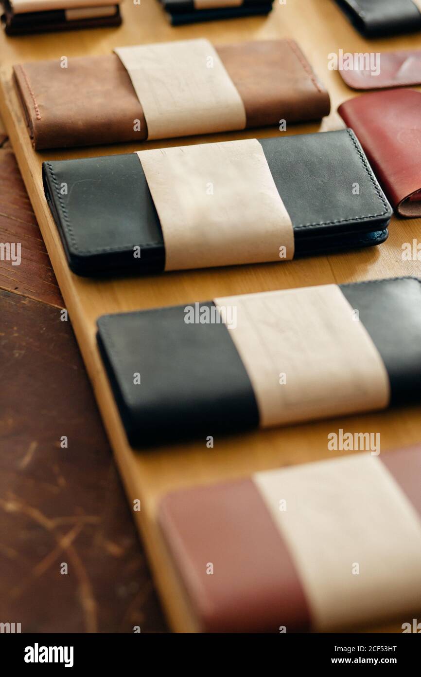 Men's accessories with brown leather bags on wooden table over wall background Stock Photo