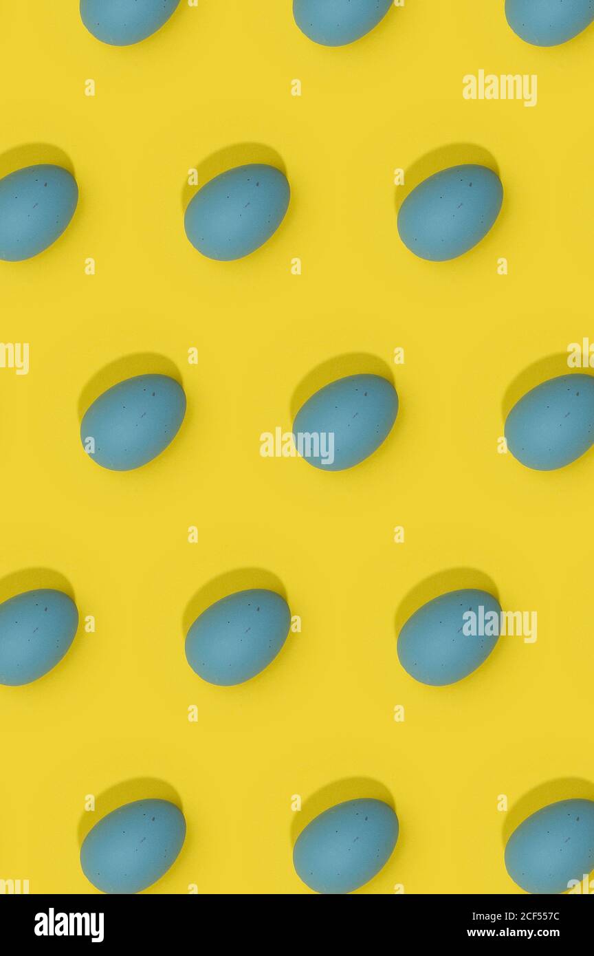 Seamless Easter pattern with colored decorated eggs arranged in rows on yellow background Stock Photo