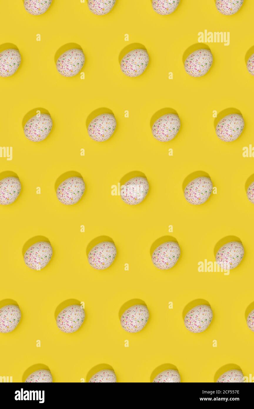 Seamless Easter pattern with colored decorated eggs arranged in rows on yellow background Stock Photo