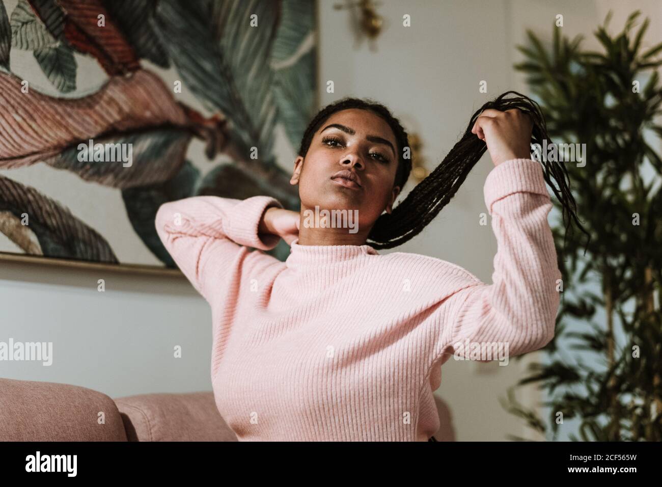 Bored young Woman sitting on sofa Stock Photo