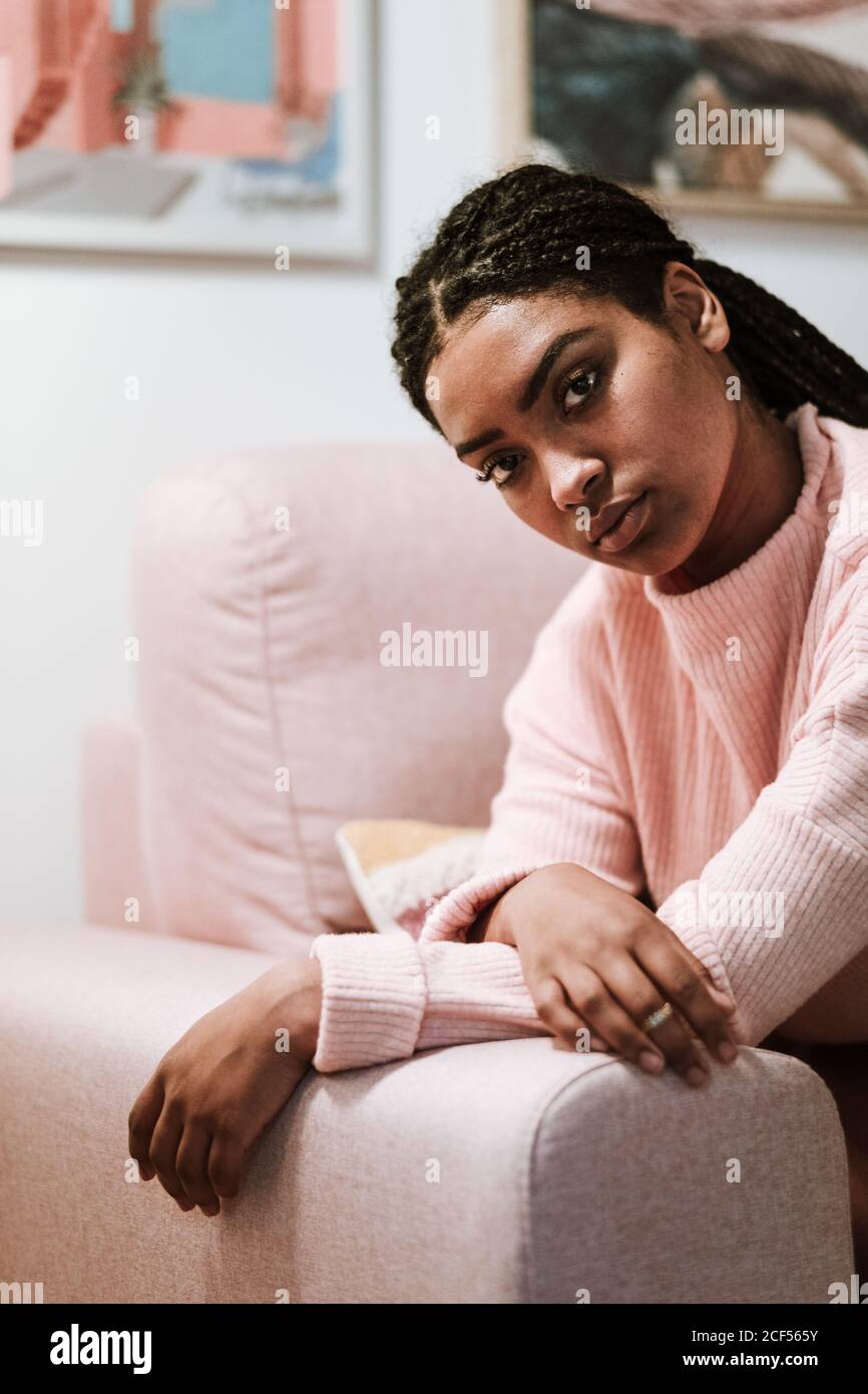 Bored young Woman sitting on sofa Stock Photo