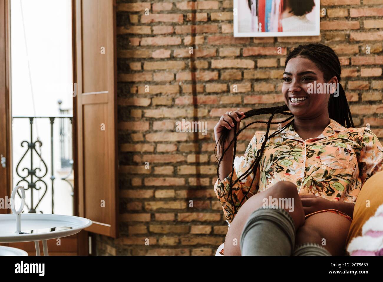 Happy ethnic Woman sitting in living room Stock Photo - Alamy