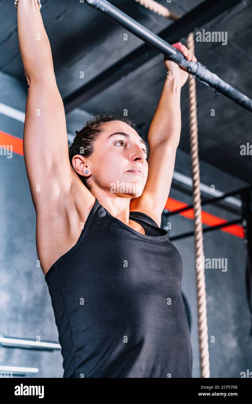 Strong Woman doing pull-up exercise with weight on horizontal bar Stock ...