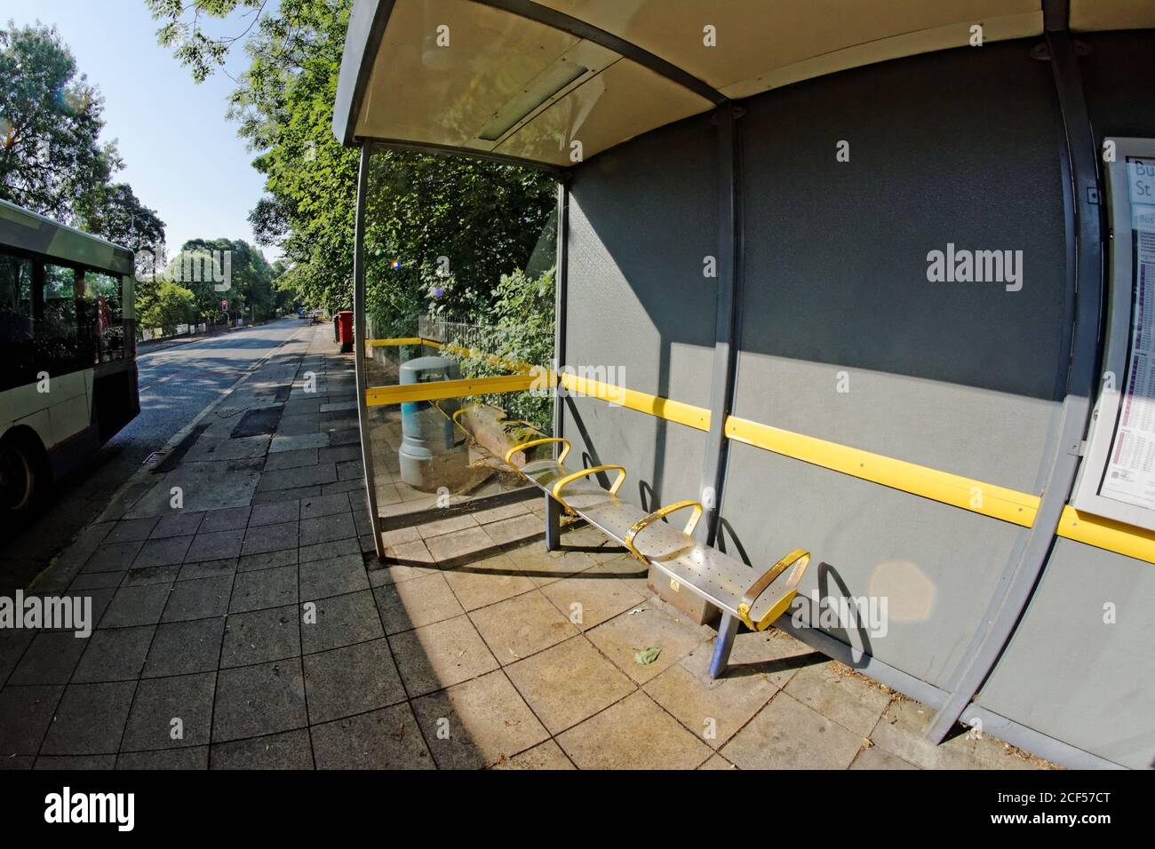 A bus stop and passing bus in Greater Manchester Stock Photo