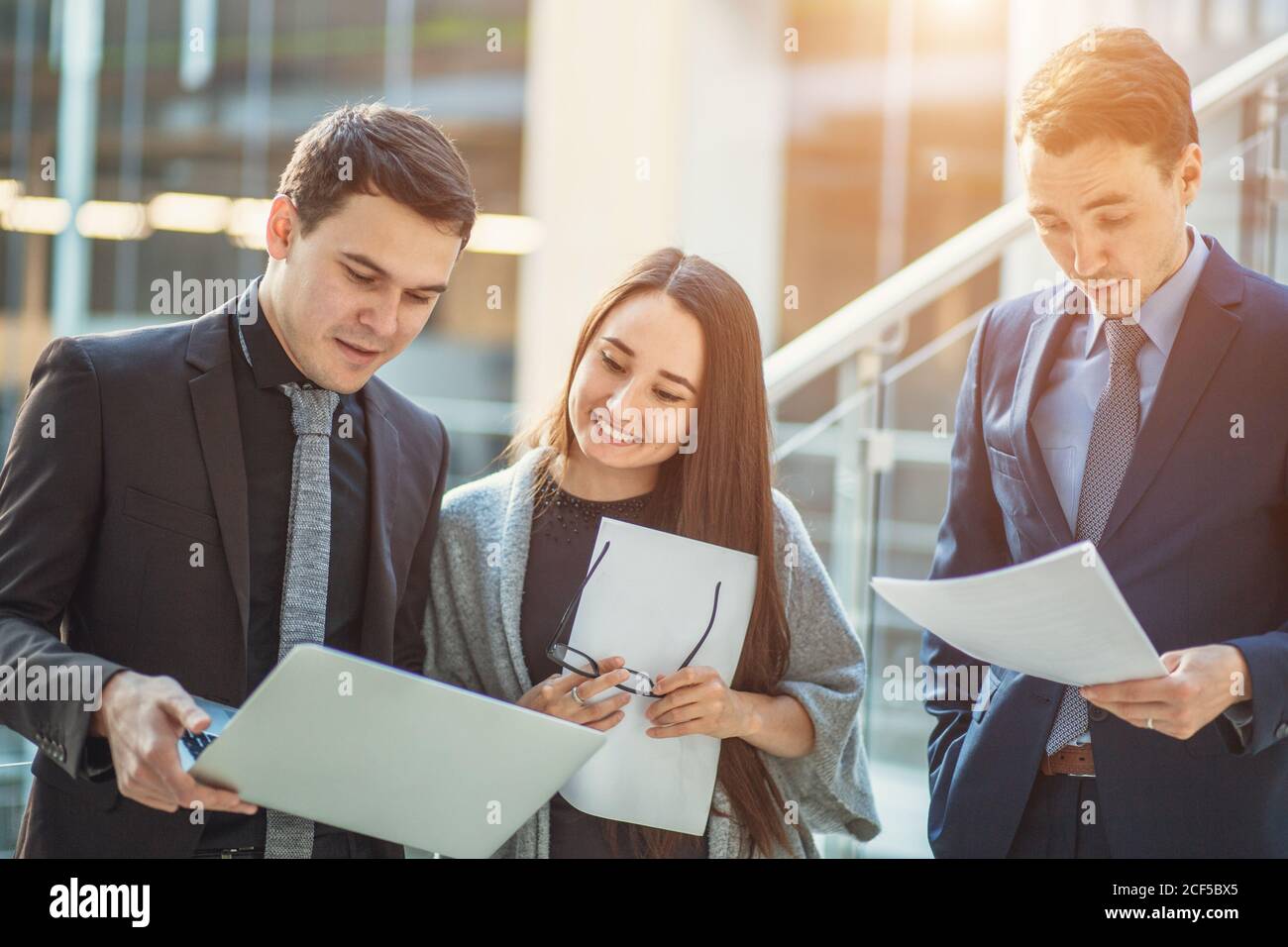 businessman holding papers hands and smiling.Young team of coworkers making great business discussion in modern coworking office Stock Photo