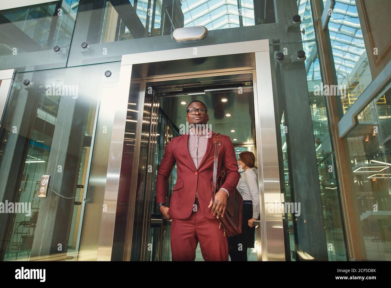 business group comes out from glass Elevator Stock Photo