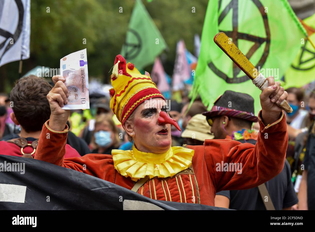 A woman dressed as Mr Punch during the demonstration.Outside the HM  Treasury buildings Protesters at the Extinction Rebellion Carnival of  Corruption marched towards Buckingham Palace but were blocked by police at  The