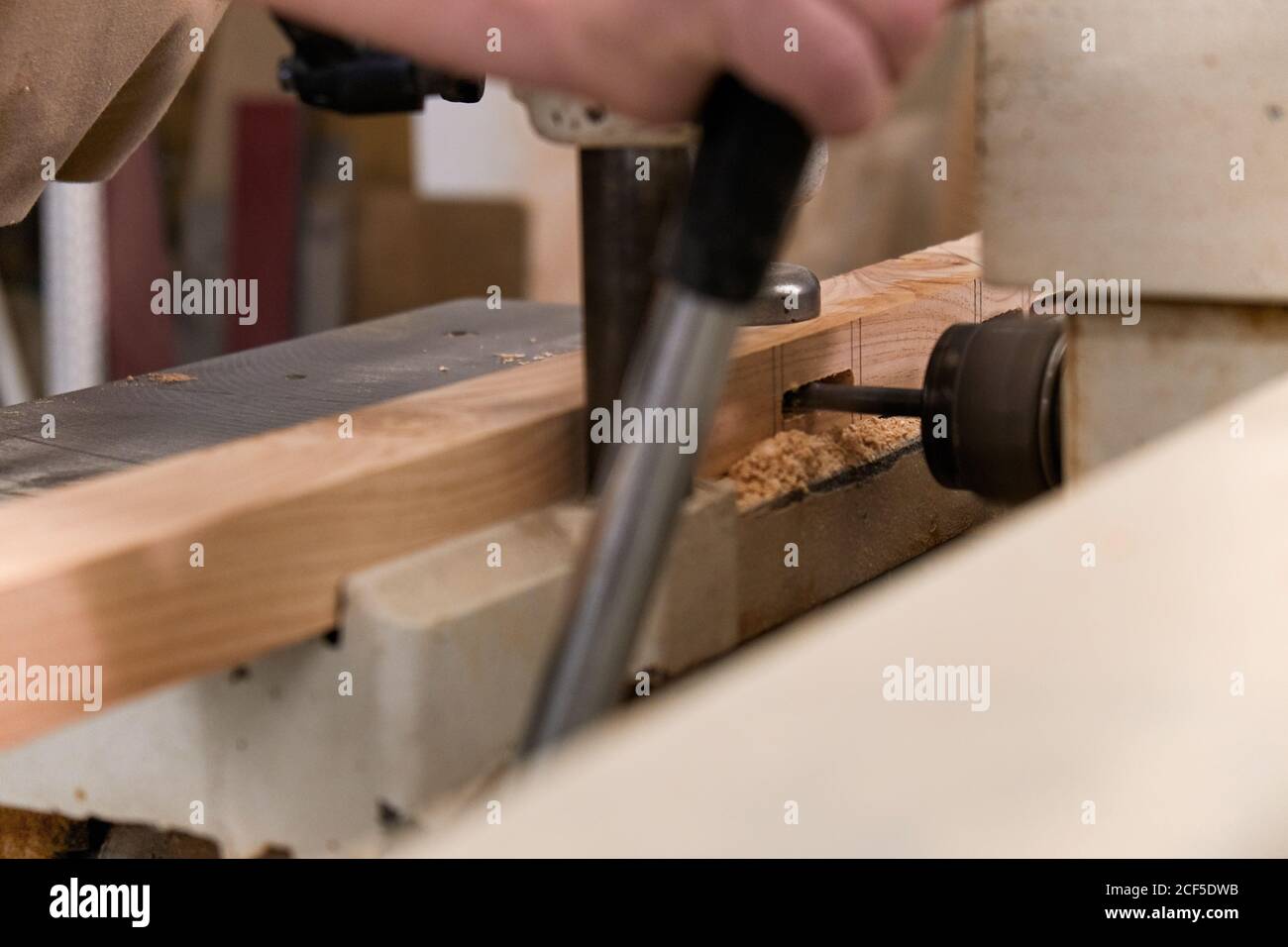 Crop man using special electric machine while working in contemporary workshop Stock Photo