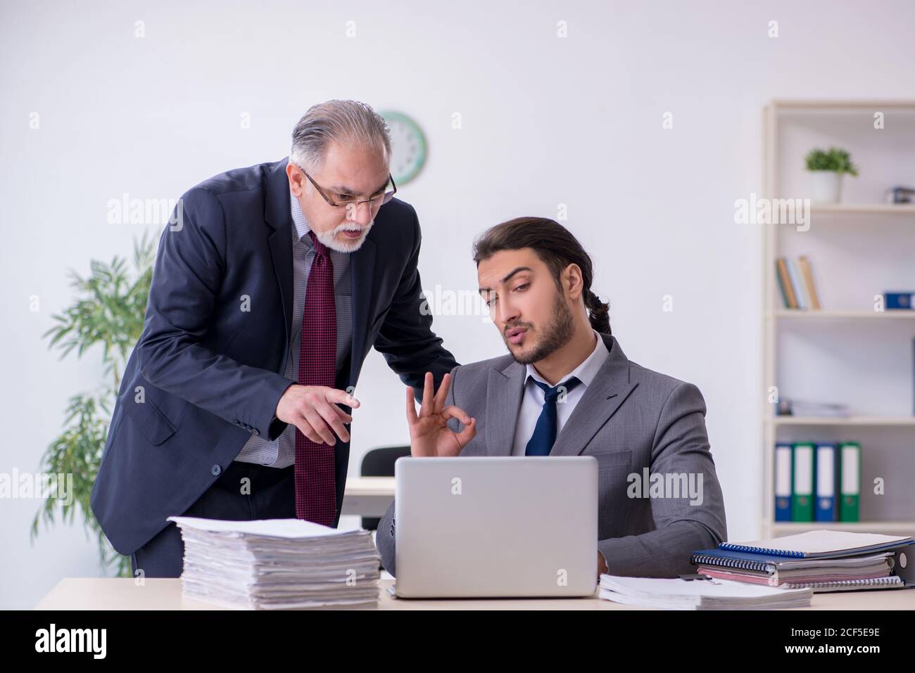Old boss and his assistant working in the office Stock Photo - Alamy