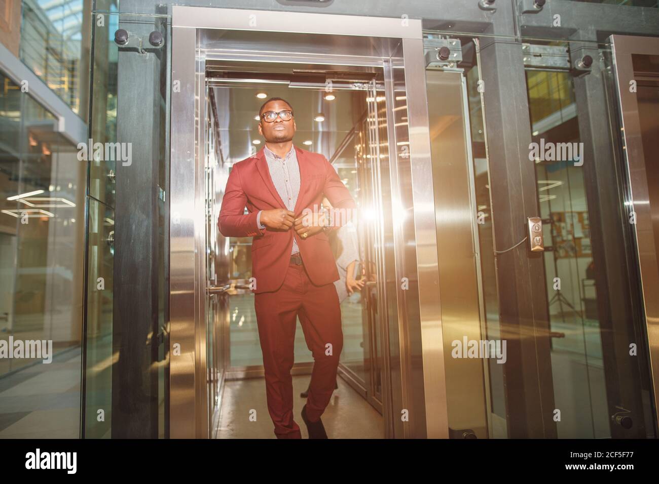 business group comes out from glass Elevator Stock Photo